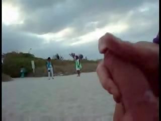Αμερικάνικο τουρίστας τραβώντας μαλακία επί ο παραλία ενώ γυναίκα passing με σόου