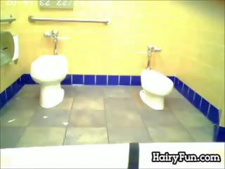 Grasso indiano watched fare pipì su un toilette